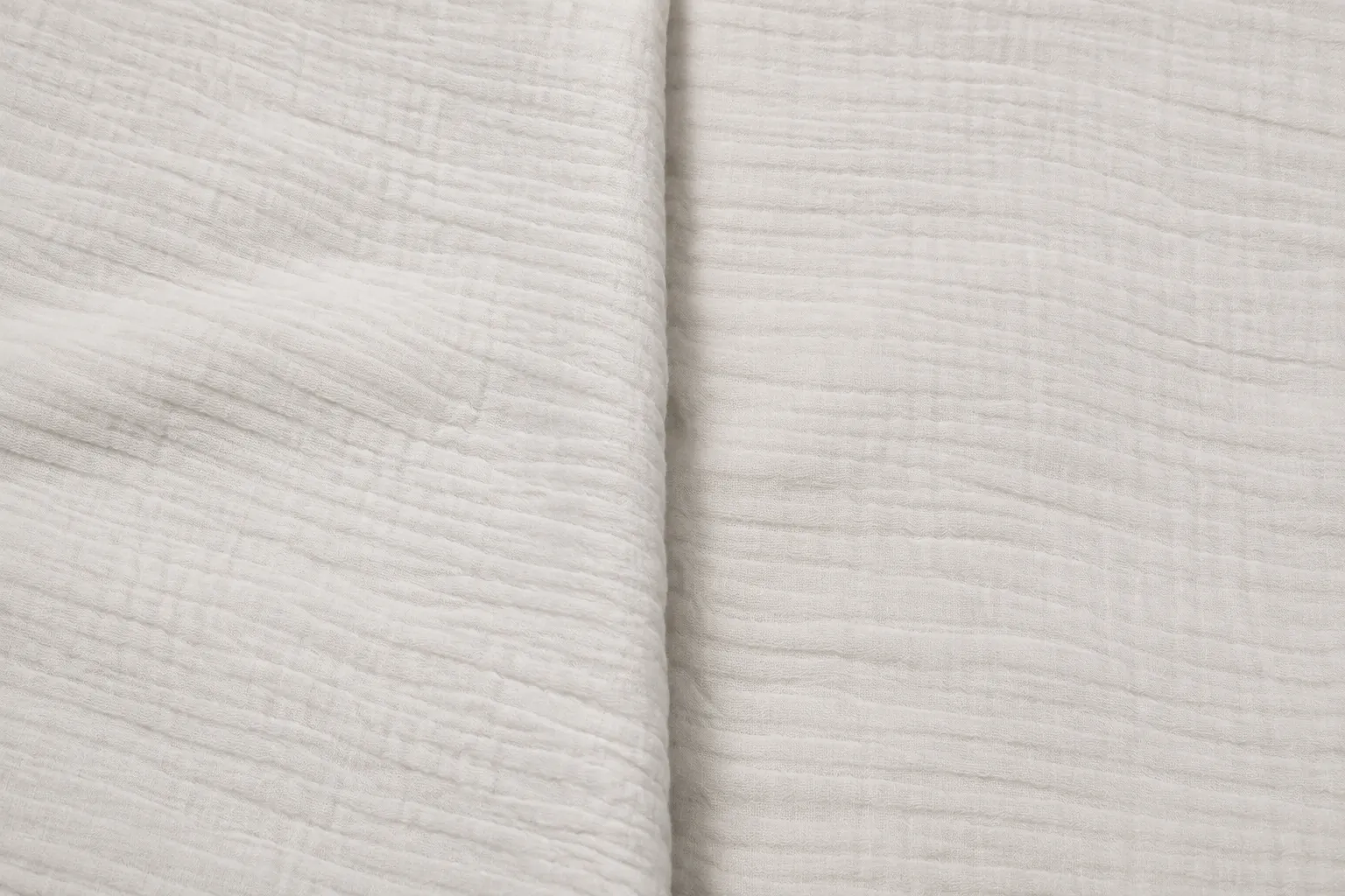 Close-up of double gauze fabric showing two bonded gauze layers with soft crinkled texture for children's dresses